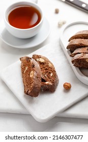Italian chocolated cantucci with almond and hazelnuts. Biscotti cookies with nuts and cup of tea. Homemade biscotti.