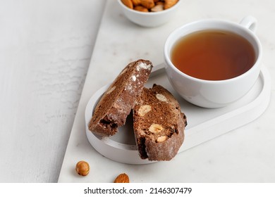 Italian chocolated cantucci with almond and hazelnuts. Biscotti cookies with nuts and cup of tea. Homemade biscotti. White background