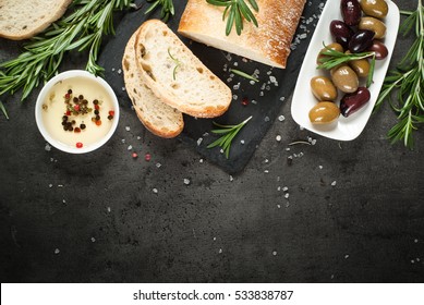 Italian Ciabatta Bread  On Black Slate Board With Herbs And Olives, Top View Mediterranean Food Background.