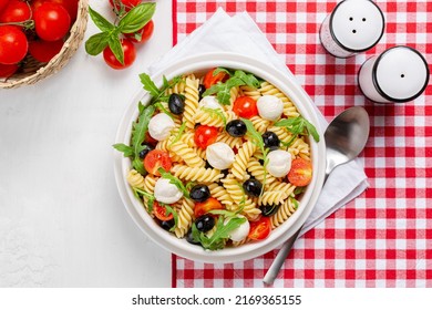 Italian Cold Pasta Salad Or Pasta Fredda Alla Caprese. Directly Above. Fusilli, Tomato, Mozzarella, Olive, Arugula. 