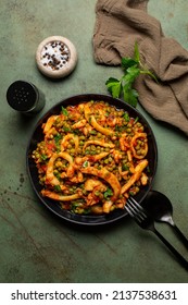 Italian Cuttlefish Stew With Peas, Tomatoes And Parsley Or Seppie Con Piselli. On Green Table Surface, Vertical Image.