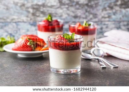 Italian dessert panna cotta in glass with strawberries.