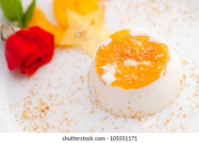 Italian dessert panna cotta on white plate decorated with coconut milk and peach. - Powered by Shutterstock