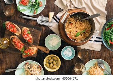 Italian Dinner Table With Pasta, Bruschetta And Salad On A Rustic Wooden Table, Top View