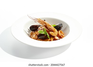 Italian Dish - Seafood Linguine Isolated On White Background. Pasta With Prawn, Mussels, Octopus,  Squid In Tomatoes Marinara Sauce. Seafood Pasta In Italian Restaurant Menu. Seafood On White Plate