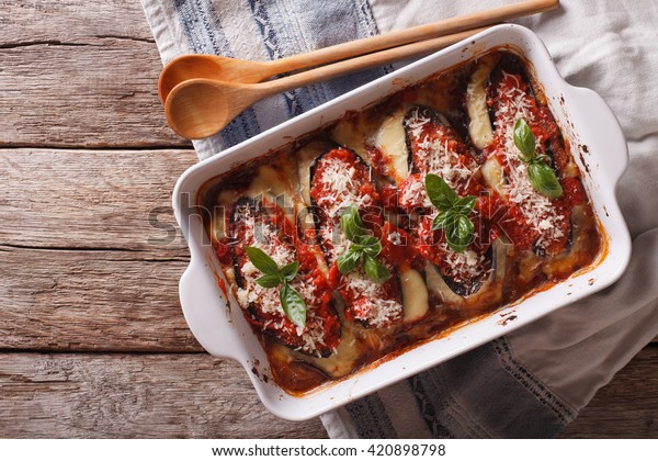 Italian eggplant with\
mozzarella in tomato sauce close up in baking dish. horizontal view\
from above\
