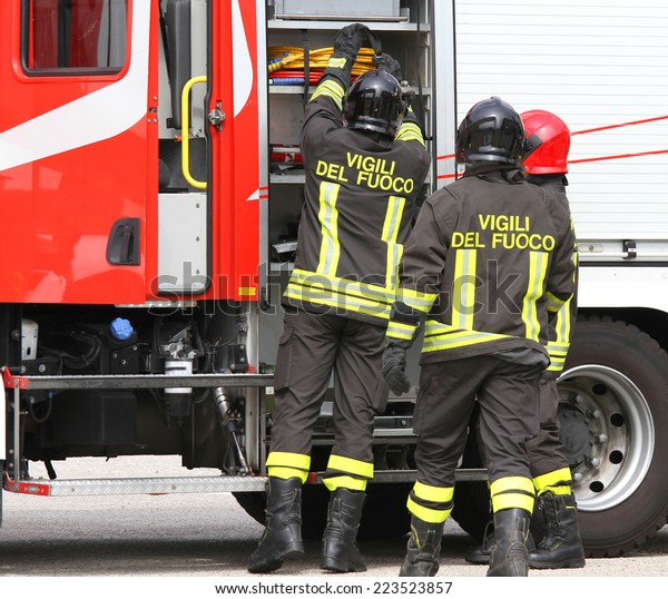 Italian firefighters working near the fire\
truck when handling an\
emergency