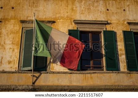 Italian Flag over window's yellow house - Italy