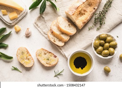 Italian food background. Fresh italian ciabatta bread with herbs, olive oil, balsamic vinegar, parmesan and olives on white background, top view, flat lay. - Powered by Shutterstock