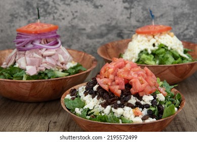 Italian Food Feast Is Set Up On The Table With Three Salads To Choose From With The Bleu Cheese Walnut Salad Featured In Front.