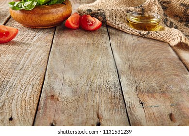 Italian Food on Old Wooden Background with Selective Focus. Table Top Perspective with Tomatoes, Basil and Olive Oil with Place for Text. Blurred Vintage Aged Boards Texture