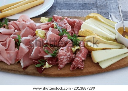 Italian food. Platter with appetizers of italian cold cuts prosciutto, salame, mortadella, pecorino cheese. Close-up. Overhead view.