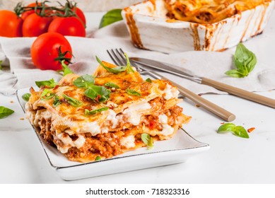 Italian Food Recipe. Dinner With Classic Lasagna Bolognese With Bechamel Sauce, Parmesan Cheese, Basil And Tomatoes, On White Marble Table, Copy Space