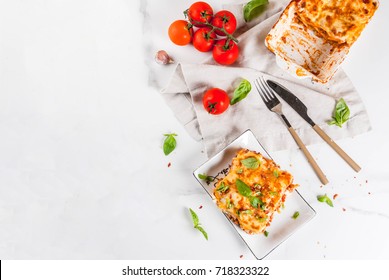 Italian Food Recipe. Dinner With Classic Lasagna Bolognese With Bechamel Sauce, Parmesan Cheese, Basil And Tomatoes, On White Marble Table, Copy Space