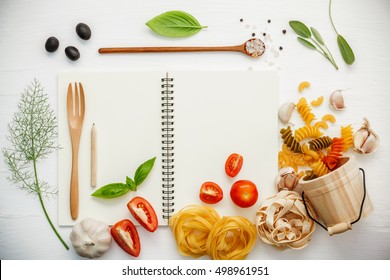 Italian foods concept and menu design . Various pasta elbow macaroni ,fusilli ,fettucini with ingredients sweet basil, sage ,black olive ,himalayan salt ,pepper and garlic setup on white notebook . - Powered by Shutterstock
