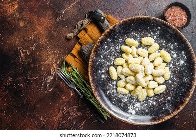 Italian Gnocchi Dumplings, Raw Potato Gnocchi On Plate With Thyme. Dark Background. Top View. Copy Space.