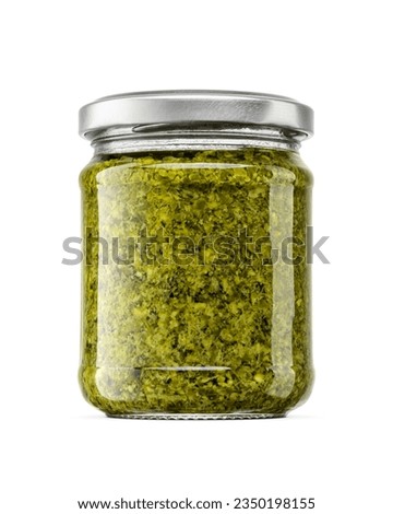 Italian green sauce pesto in small glass jar with silver twist off lid isolated on a white background.