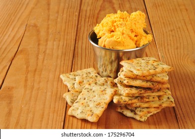 Italian Herb Flatbread Crackers With Bacon Cheddar Cheese Spread On A Rustic Wooden Surface