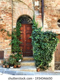 Italian House. Facade Decorated With Flowers And Ivy. Wooden Door. Photo Made In Toscana. 