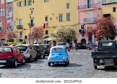 Italian little car fiat 500 blue in the streets of Procida Island Naples in Italy. The world famous Italian automobile brand. Rome Amalfi Venice Milan. Italian street colours. town traffic road day
