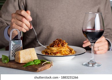 Italian Man During Dinner With Red Wine. Egg Pasta Tagliatelle With Bolognese Sauce Made From Meat And Tomato Sauce, Parmesan Cheese. 
