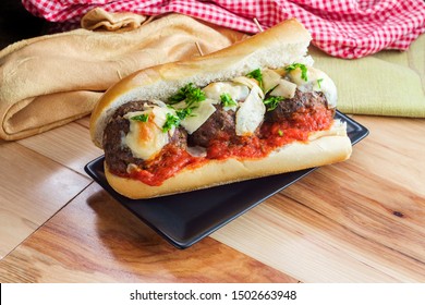 Italian Meatball Parmesan Hero Sandwich On A Torpedo Roll With Parsley Garnish