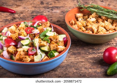 Italian panzanella salad with ciabatta croutons on the table in a bowl - a beautiful multicolored vegetarian dish