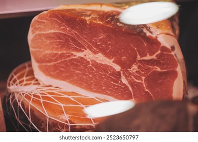 Italian Parma ham on supermarket. Prosciutto Crudo, showcasing, marbled texture and deep red color. This Italian dry-cured ham is perfect for charcuterie boards, gourmet sandwiches and antipasto  - Powered by Shutterstock