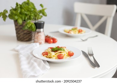 Italian Pasta With Cherry Tomatoes And Garnished With A Sprig Of Parsley. Table Setting For Dinner.