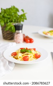 Italian Pasta With Cherry Tomatoes, Tomato Sauce And Cheese, Garnished With A Sprig Of Basil. Ready Lunch Or Dinner. Table Setting