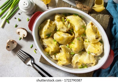 Italian pasta Conchiglioni Rigati stuffed with chicken, royal champignons, baked with cheese in bechamel sauce on a gray stone countertop. Top view flat lay background.