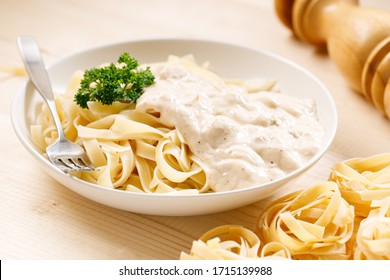 Italian Pasta Fettuccine With White Creamy Sauce In White Plate On Wooden Background