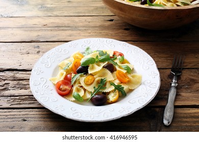 italian pasta salad with tomatoes and herbs on rustic table background - Shutterstock ID 416946595