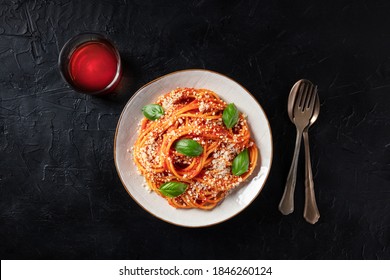 Italian Pasta. Spaghetti With Tomato Sauce, Grated Parmesan Cheese And Fresh Basil, Overhead Shot On A Dark Background With A Glass Of Wine
