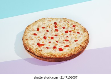 Italian pizza with chicken and paprika on coloured background. Cheese pizza with chicken and corn in minimal style on blue and purple color. American pizza delivery concept with color backdrop.