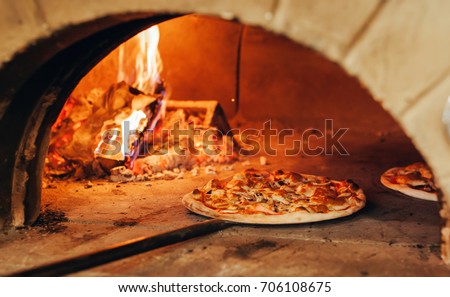 Italian pizza is cooked in a wood-fired oven.