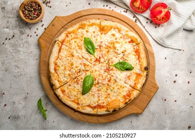 pizza italiana Margherita con queso, salsa de tomate y albahaca en la mesa de hormigón gris vista arriba