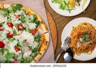 Italian Pizza And Pasta Served In The Wooden Table