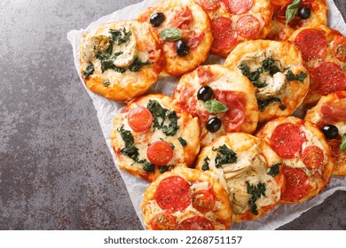 Italian Pizzette Mini Pizza Bites With Assorted Toppings close-up on parchment on the table. Horizontal top view from above
 - Powered by Shutterstock