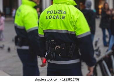 Italian police squad patrol formation back view with "Local Police" logo emblem on uniform maintain public order in the streets of Venice, Venezia, Italy - Powered by Shutterstock