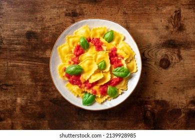 Italian Ravioli With Red Tomato Sauce And Basil, Overhead Shot On A Dark Rustic Wooden Background