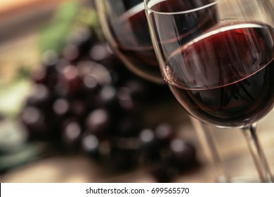 Italian red wine tasting and wine culture: wine glass and grape on a rustic wooden table