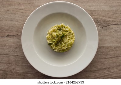Italian risotto with asparagus. Creamy asparagus risotto on wooden background.