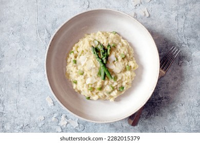 Italian risotto with asparagus and parmesa cheese on table. Top view.