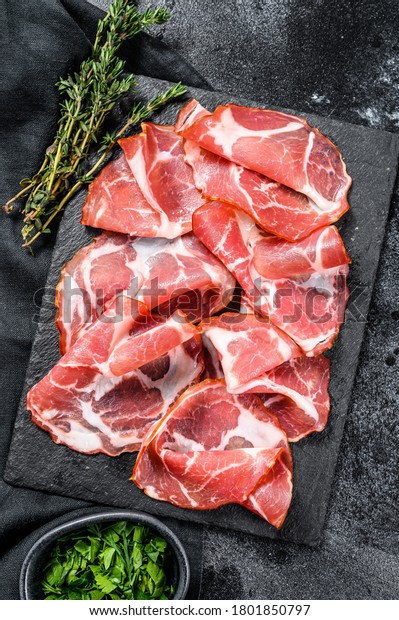 Italian rolled bacon Pancetta Piacentina. Pork meat.
Black background. Top
view