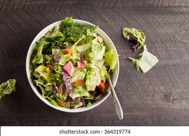 Italian salad with freshly harvested organic vegetables including endive, red cabbage, carrots, butter heart lettuce, romaine, and green lettuce with Italian dressing top view