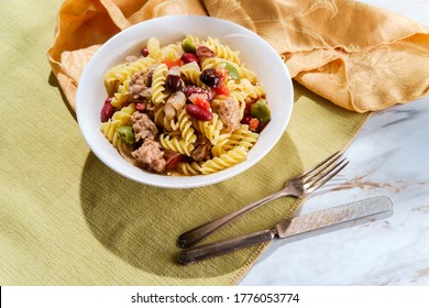 Italian sausage rotini pasta with castelvetrano and kalamata olives and kidney beans in a light tomato white-wine butter sauce - Powered by Shutterstock