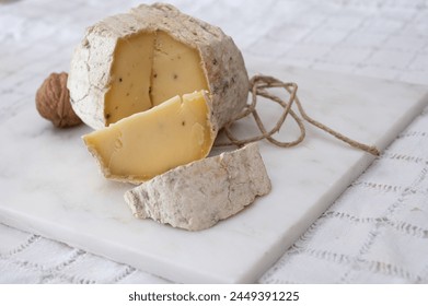 Italian small piece of hard cheese truffelino romano with black summer truffles mushrooms close up - Powered by Shutterstock