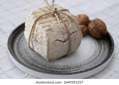 Italian small piece of hard cheese truffelino romano with black summer truffles mushrooms close up - Powered by Shutterstock