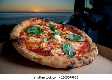 Italian Style Pizza With A Sunset In The Background Near The Sea